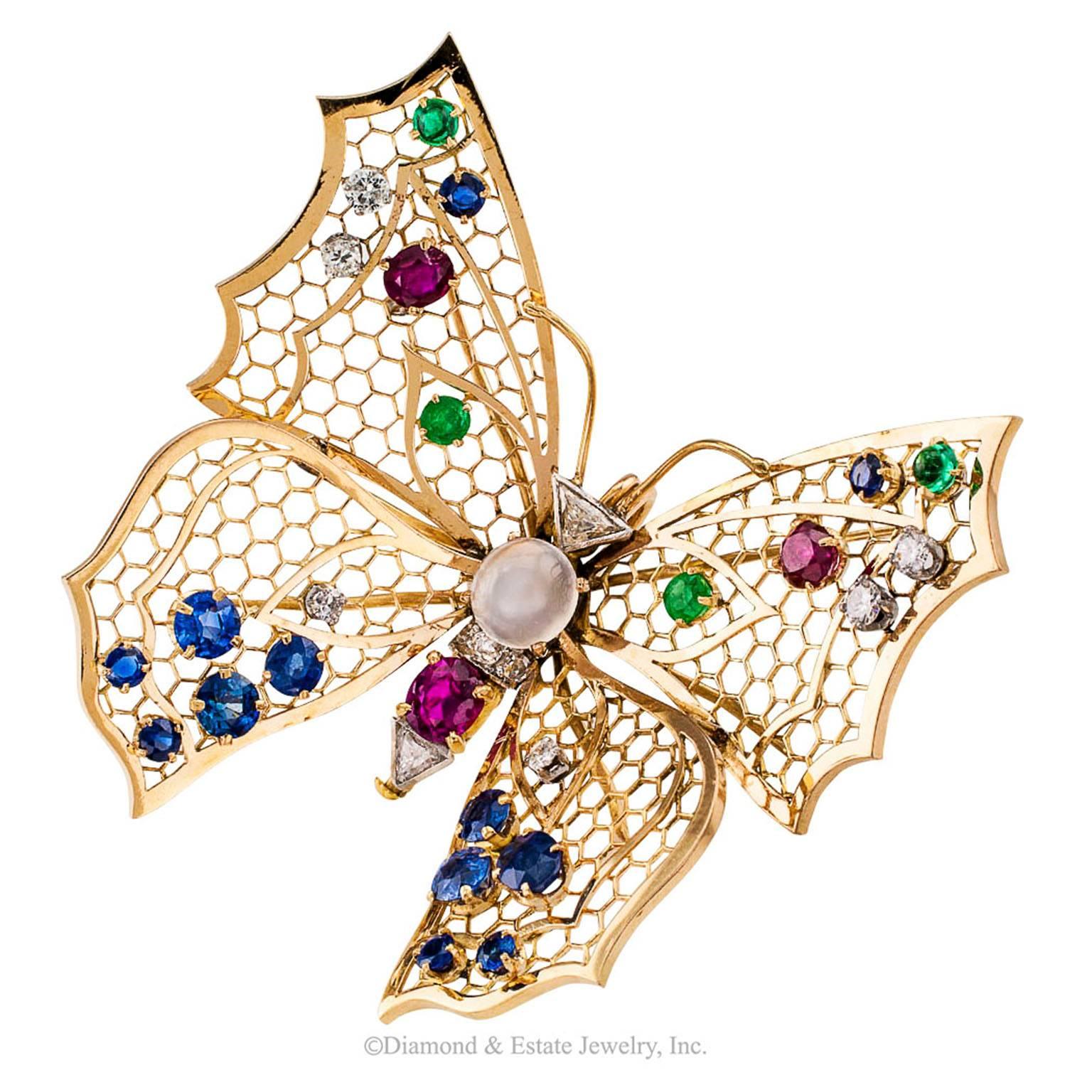 Butterfly Gold Brooch Diamonds Emeralds Moonstone Rubies Sapphires

Mid century butterfly brooch wings and body set with  diamonds emeralds a moonstone rubies and sapphires 18-karat yellow gold circa 1950.  Light and delicate as a real butterfly in