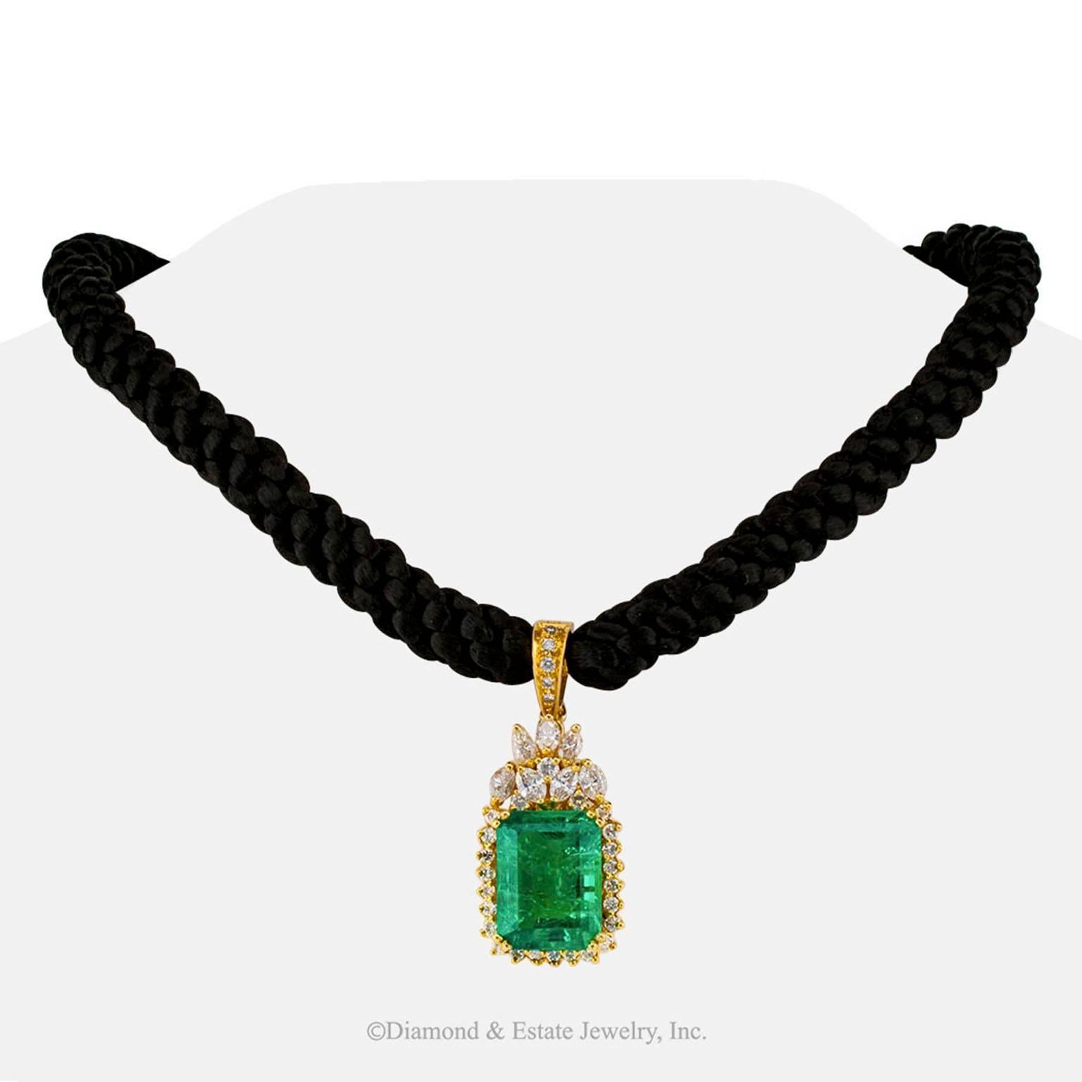 Colombian Emerald Diamond Gold Enhancer Pendant

Emerald-cut 14.00 carats Colombian emerald and diamond gold enhancer pendant circa 1990.  Take-your-breath-away Colombian emerald color beaming from the approximately 14.00 carats emerald-cut emerald,