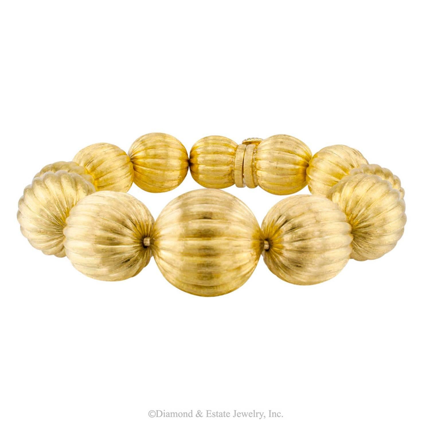 1970s Gold Bead Bracelet

1970s 18-karat gold bead bracelet.  The design features a course of twelve graduating 18-karat yellow gold beads decorated with melon-fluting and a Florentine finish that lends the orbs a glowing characteristic, as if they