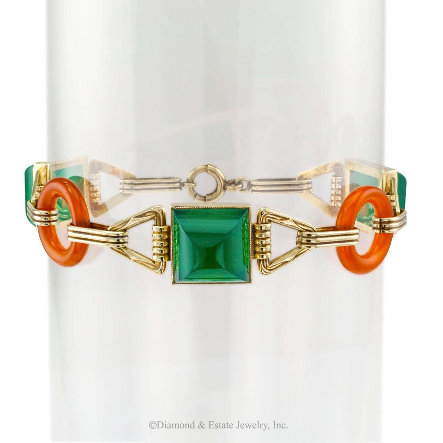 Art Deco 1930s Green Onyx Carnelian Gold Bracelet

Art Deco 1930s green onyx carnelian and 14-karat gold link bracelet.  Comprising a pair of carnelian circular links at even intervals between a trio of bezel-set  sugar-loaf green onyx cabochons,