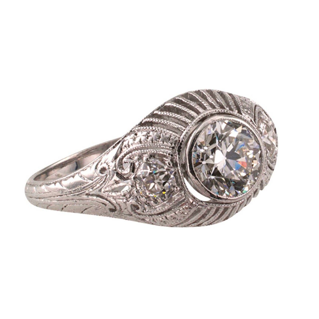 Three-stone Edwardian Diamond Platinum Engagement Ring

This wonderfully domed platinum diamond ring is lavishly decorated with fine open work, chased motifs and millegrain, in the style that was so popular with the Edwardians.  It's set with
