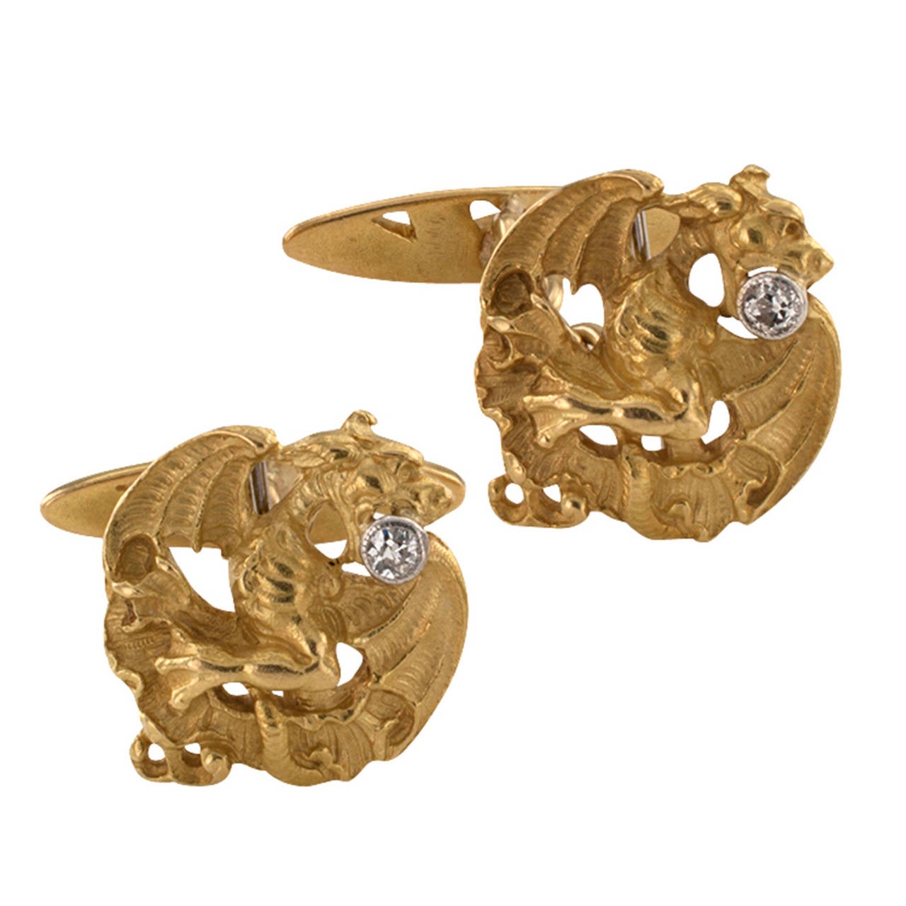 Art Nouveau Griffin Cuff Links With Diamonds

A pair of three dimensional  fierce griffins executed in great detail, completed by back supports embellished with classic organic motifs prevalent in Art Nouveau jewels.  The matching designs feature
