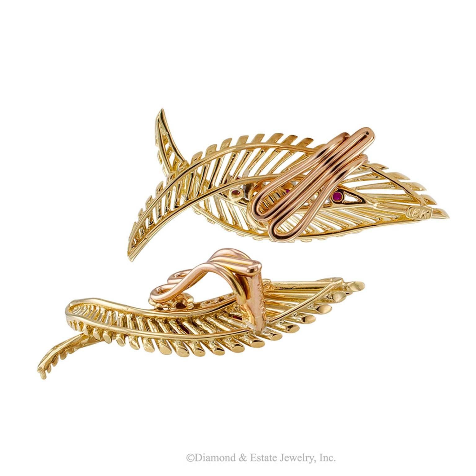 Tiffany & Co 1950s Ruby Diamond Gold Retro Ear Clips

Tiffany & Co 1950s ruby and diamond retro gold ear clips.  Matching left and right designs  styled as abstract  leaf motifs entirely handcrafted in 18-karat gold featuring graduating filaments