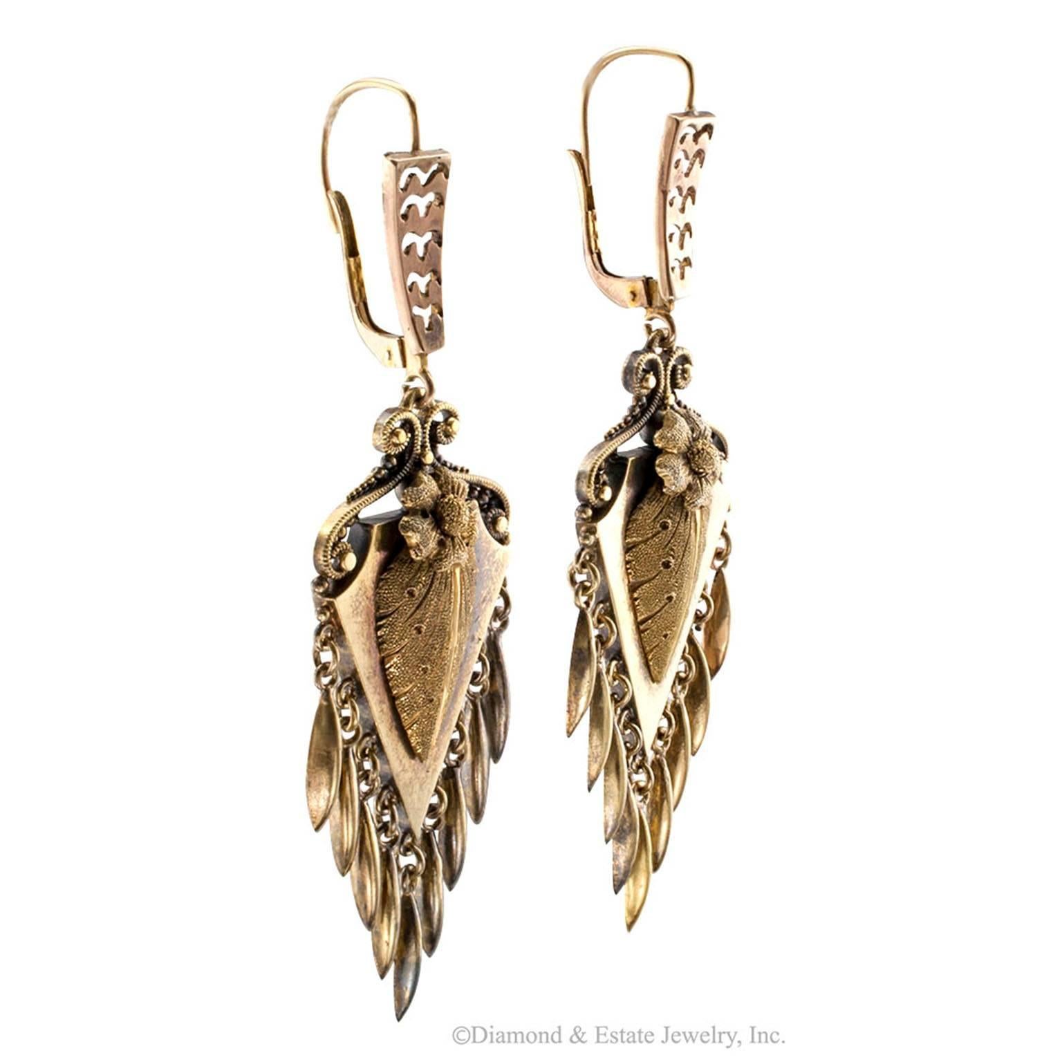 Victorian 1880s Gold Pendent Earrings

Victorian 1880s gold pendent earrings.  The matching surmounts suspending arrowhead-shaped motifs lavishly decorated  throughout by a single flower supported by an acanthus leaf, the latter, both finished in