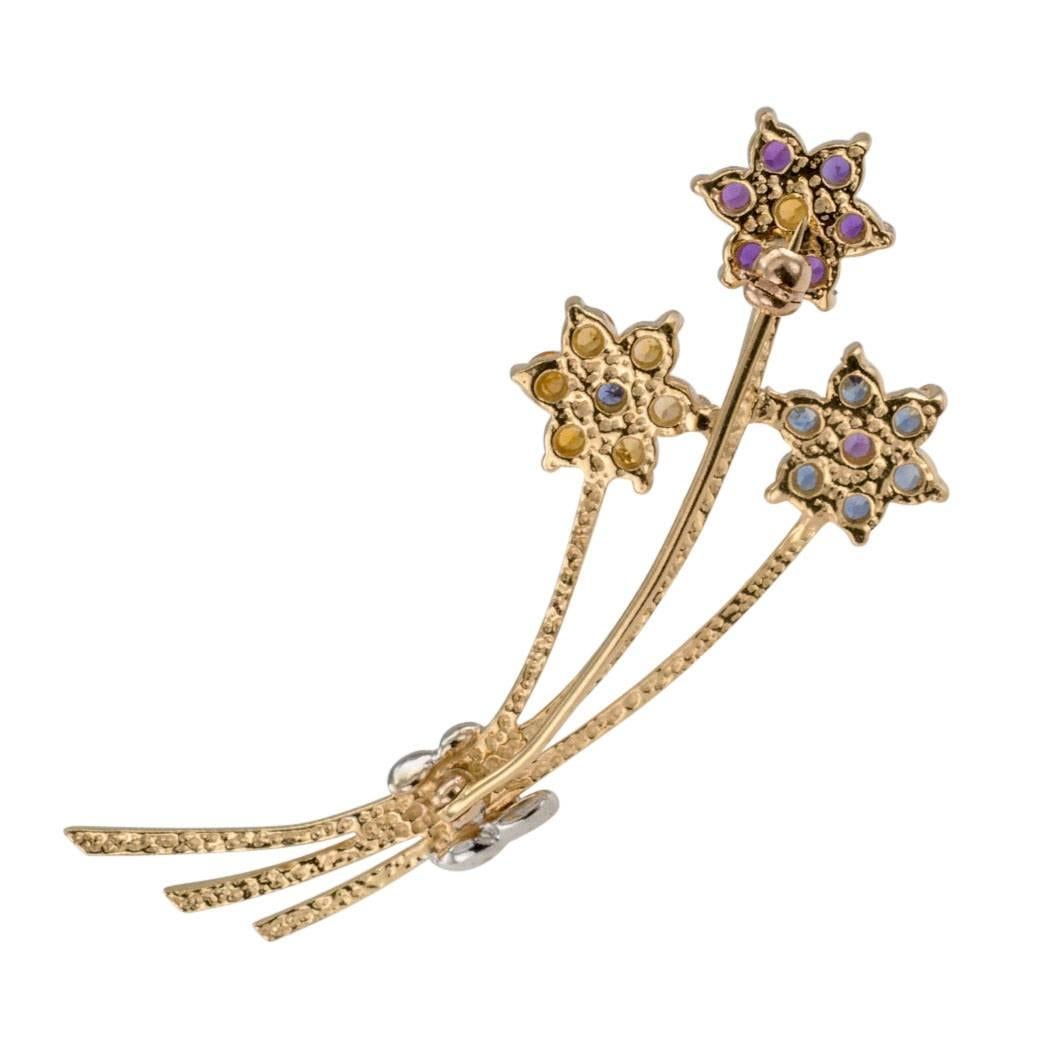 1970s Amethyst Citrine Sapphire Gold Brooch Bouquet

Flower bouquet gold brooch circa 1970 set with amethyst citrine and sapphire.  Designed as a simple three flower bouquet mounted in two-tone 14-karat gold, the long stem flowers feature petals and