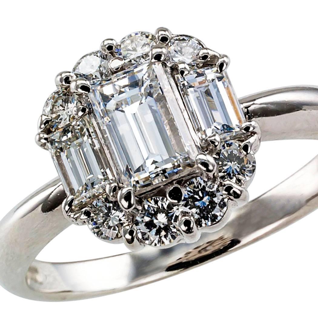 Three Stone Rectangular Diamond Platinum Engagement Ring

Diamond and platinum cluster engagement ring.  The design centers upon a rectangular-cut diamond weighing 0.50 carat, approximately F - G color and VS clarity,  between a pair of smaller