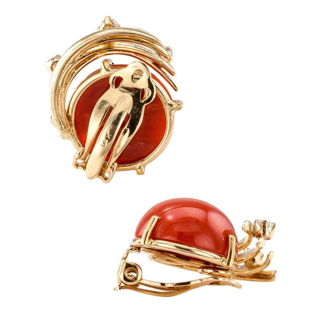 1960s Red Coral Diamond Gold Earrings

Red coral and diamond gold ear clips circa 1960.  The left and right matching designs feature a pair of red coral cabochons framed to one side by gold spray motifs studded at intervals with round brilliant-cut