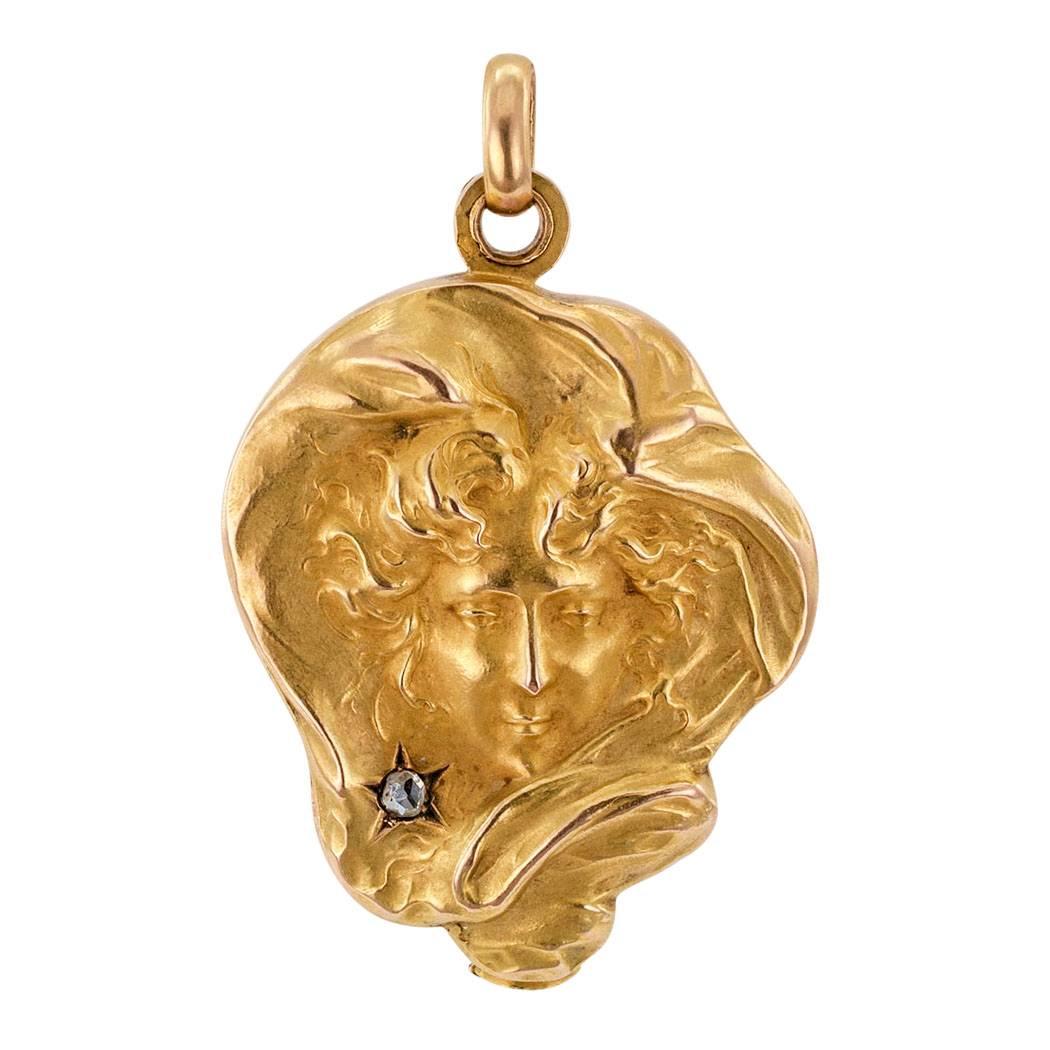 French 1905 Art Nouveau Diamond Gold Locket

French 1905 Art Nouveau  gold and diamond locket locket.  The free form locket depicts in relief an idealized woman's face, as in a state of  ethereal ecstasy, her cheek caressed by a star-set rose-cut