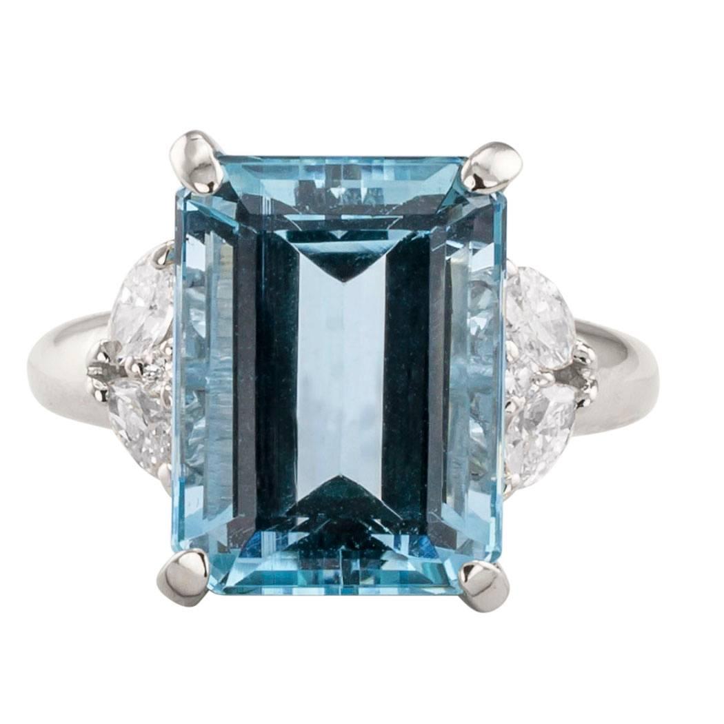 Emerald cut aquamarine and diamond platinum ring circa 1990.  Centering upon an emerald-cut aquamarine weighing 6.08 carats, between shoulders set with twin marquise diamonds cuddling a round brilliant-cut diamond.  the diamonds together totaling