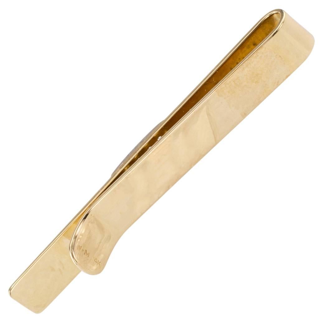 Neiman Marcus 1960s gold and diamond tie bar. The rectangular design centers upon a similarly-shaped diamond pave motif balanced by hand chased organic gold textures. All very typical of the period when it was made, but firmly grounded on timeless