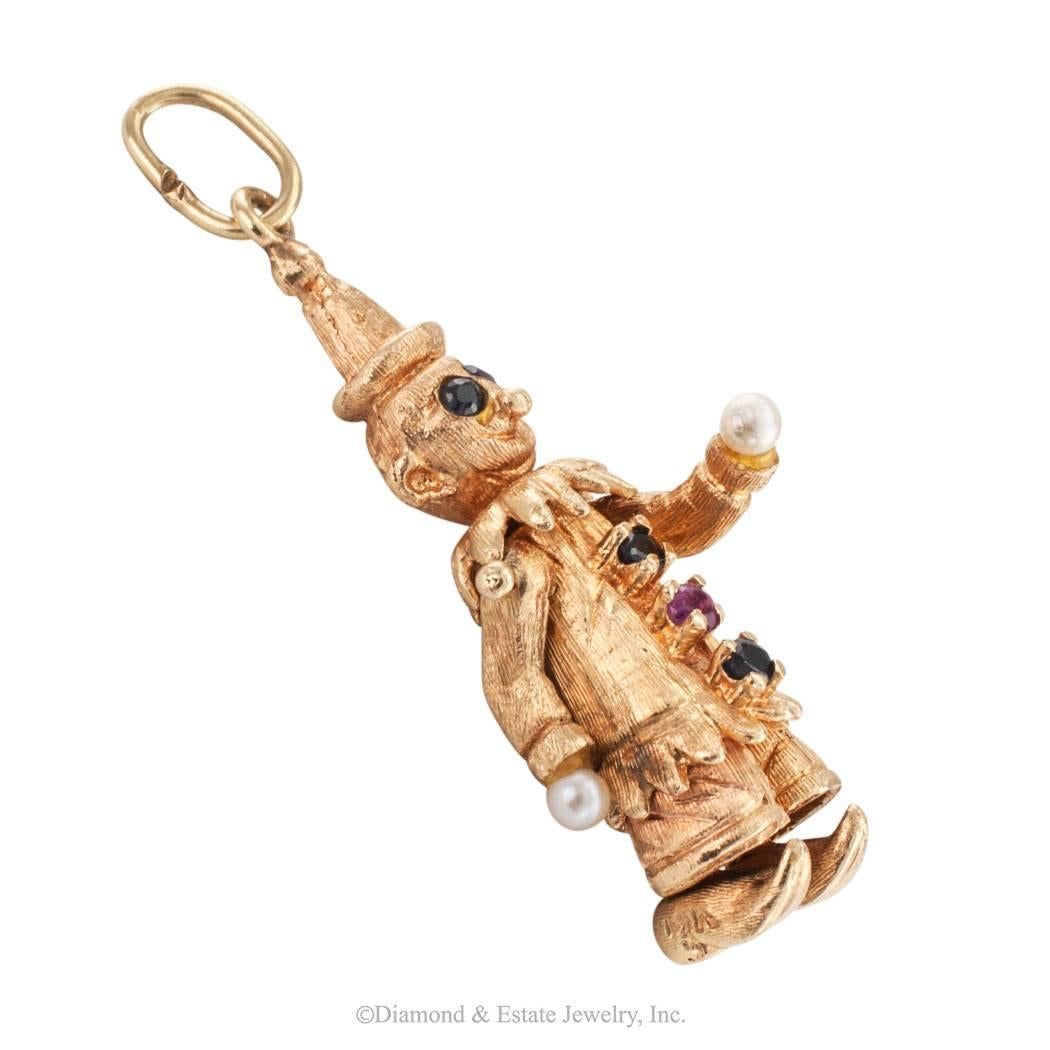 Clown gold charm pendant circa 1960 set with ruby sapphire and pearls. Articulated arms, neck and feet, set with a single ruby at the belly , sapphires eyes and buttons, pearl hands, mounted in 14-karat yellow gold, all very typical of the period
