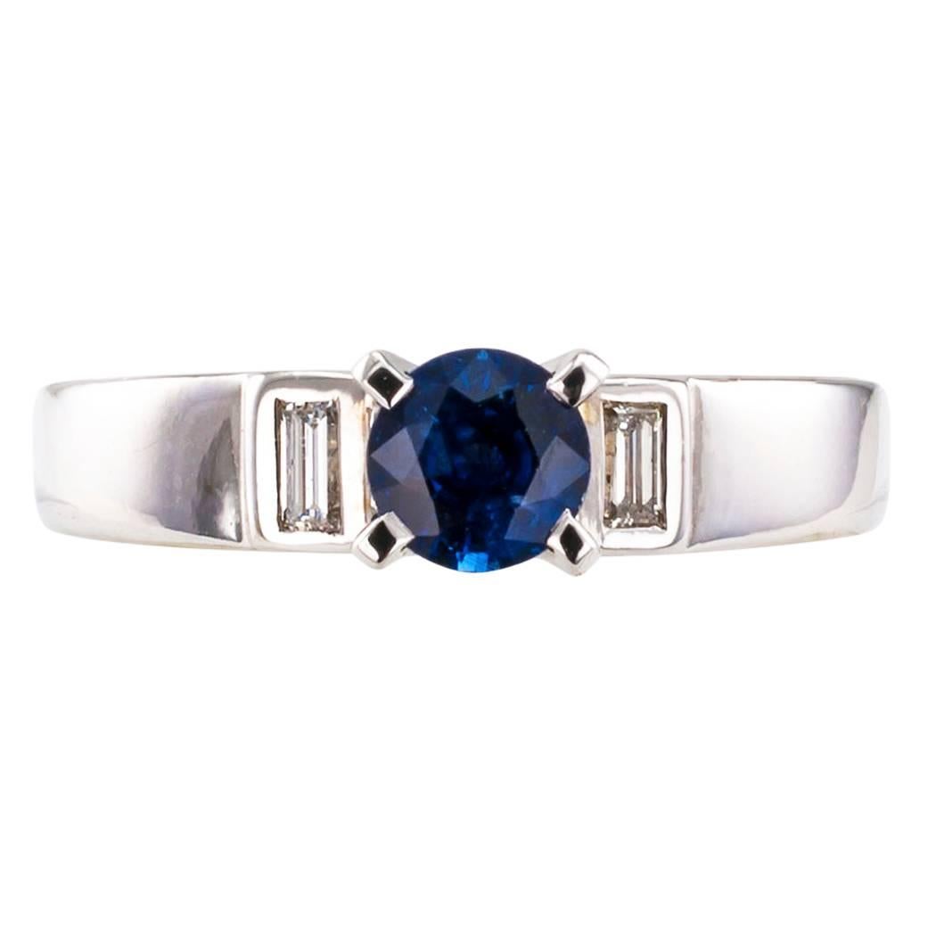 1960s sapphire diamond white gold engagement ring. Centering upon a round royal blue sapphire weighing approximately 0.50 carat, between shoulders burnish-set with a pair of baguette diamonds totaling approximately 0.10 carat, approximately H color