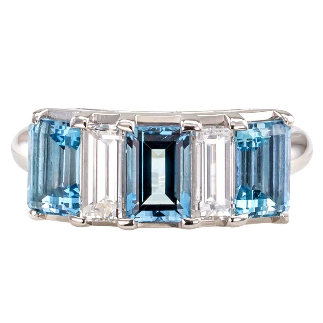 Aquamarine diamond and platinum five stone ring circa 1990. Featuring a trio of emerald-cut aquamarines weighing 1.71 carats between a pair of large rectangular baguette diamonds totaling 0.78 carat, approximately G color and VS clarity, mounted in