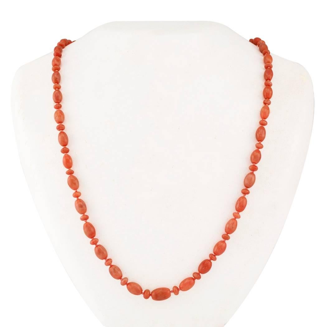 Antique 1890s coral bead necklace with gold clasp. Comprising a series of alternating oval and flat/round salmon-colored coral beads, the oval beads graduating from approximately 8 X 11 to 4 X 7 mm, completed by a simple 14-karat yellow gold clasp.