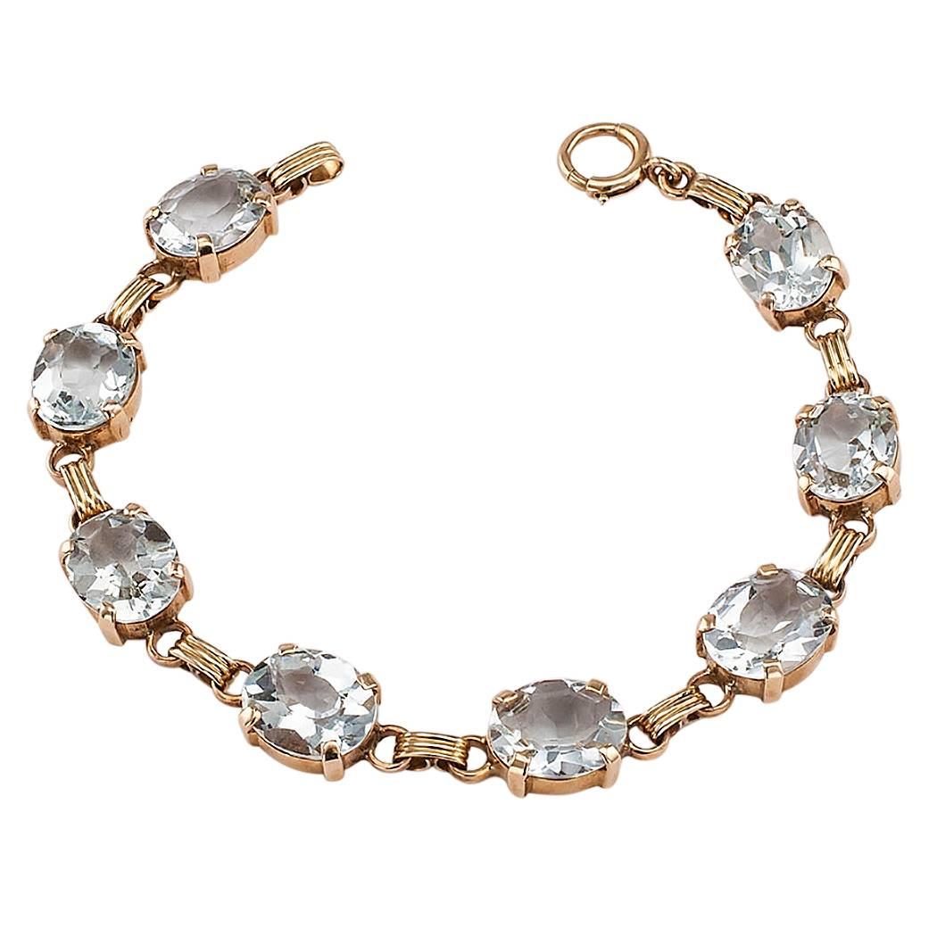Mid century 1950s aquamarine and gold line bracelet. Comprising a series of eight oval aquamarine stones totaling approximately 18.00 carats, mounted in 14-karat gold. This enchanting bracelet dating back to the middle of the twentieth century