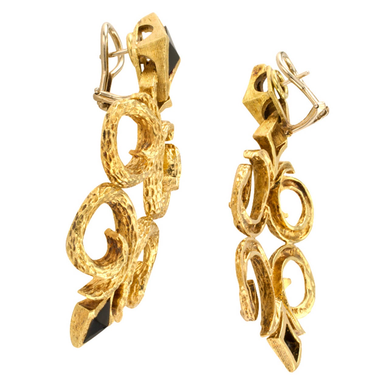 Diamond-shaped onyx motifs within conforming gold frames comprise the surmounts and bottoms of this articulated and larger scale pair of earrings.  Between them is an open quatrefoil gold design embellished throughout with rich, evocative and exotic