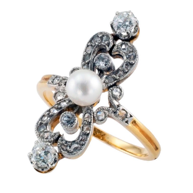 Edwardian Pearl & Diamond Ring, Circa 1910
Many jewels are full of symbolic elements.  This French platinum and 18 karat gold ring centers upon a single 5 mm pearl set between a pair of diamond heart-shaped motifs.  Produced by a living sea