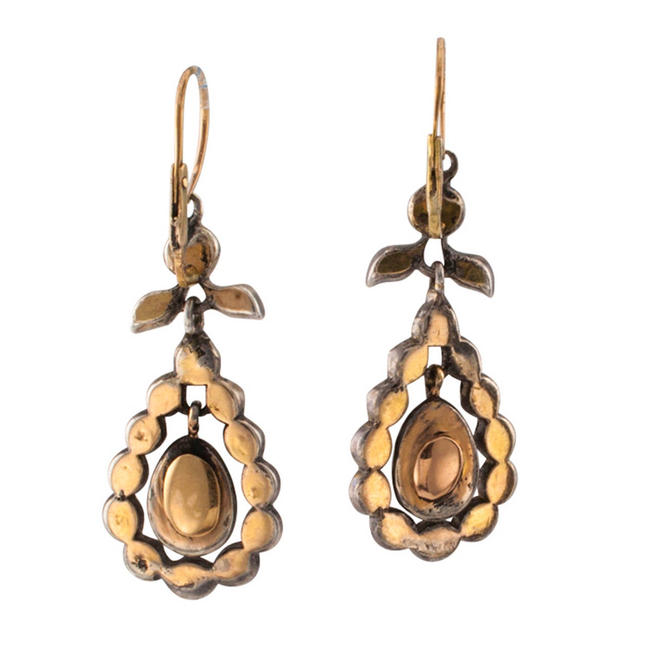 Antique Georgian Diamond Pendant Earrings

The articulated designs feature foliate inspired surmounts with pendant teardrop-shapes, set throughout with rose-cut diamonds, crafted in silver and  15 karat gold, the hinged wire backs open from the