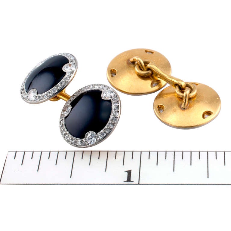 These special circular designed double sided cufflinks with scalloped diamond borders are set with rose cut and old round cut diamonds, along with a black onyx center.  Signed Cartier, Made in France, and Numbered 01672.  Approximately 1/2