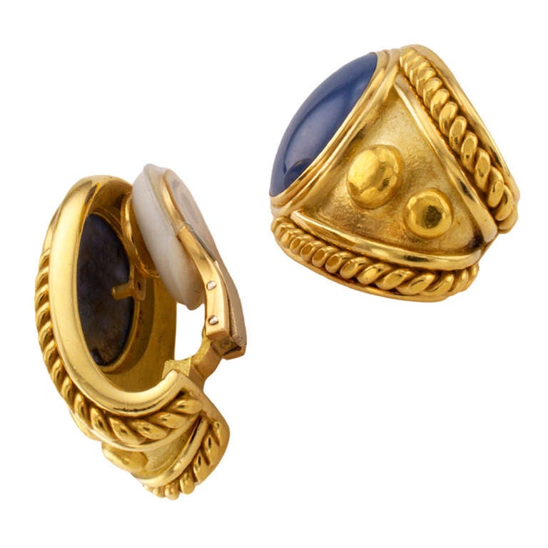Fashionable and contemporary in very self-assured way clearly defines these earrings set with a pair of light blue-gray cabochon sapphires, crafted in 18 karat gold employing all the high standards of quality and workmanship De Vroomen is famous