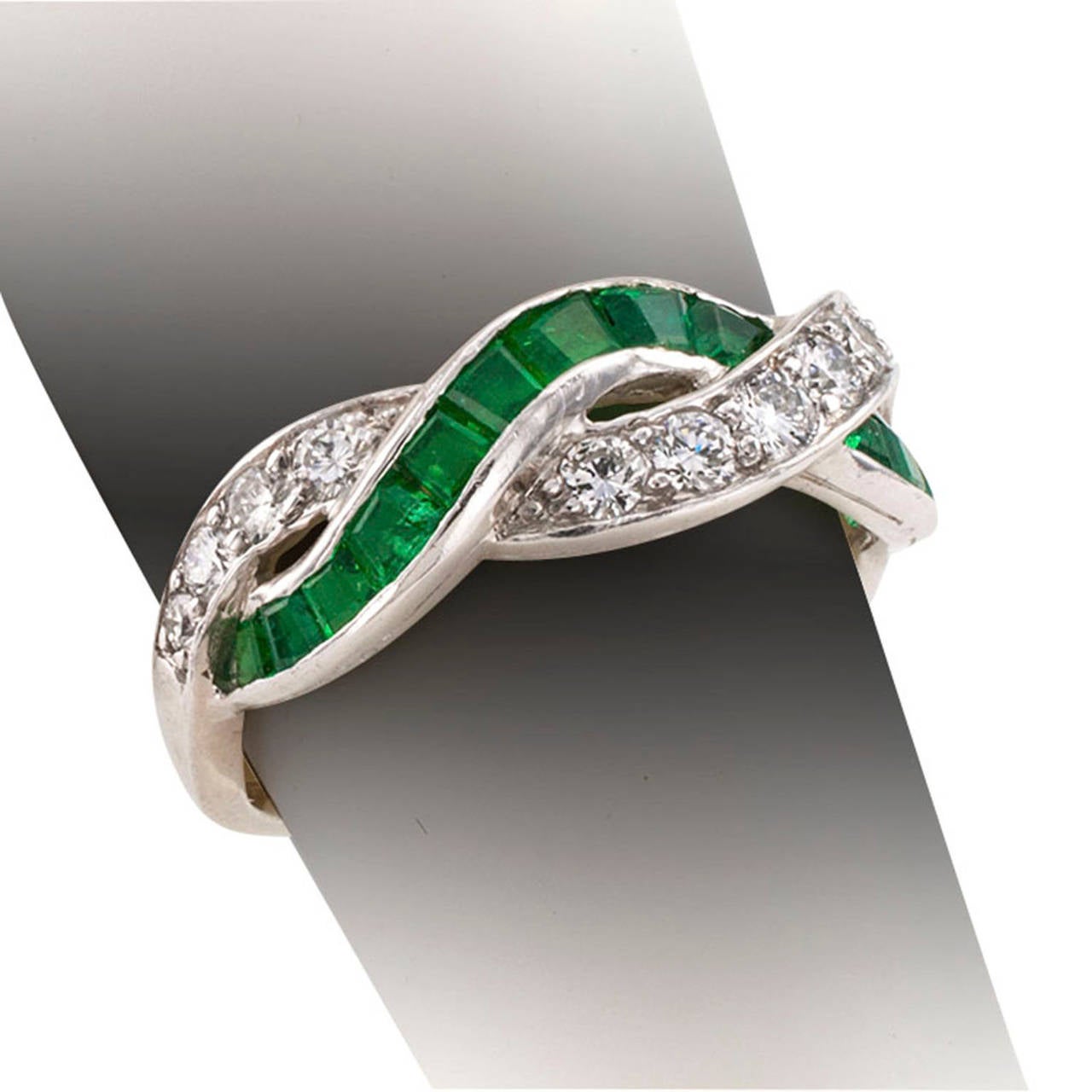 Tiffany & Co. Estate Emerald And Diamond Ring Band

A row of bright and green calibrated emeralds interlaced with a a row of sparkling round brilliant-cut diamonds totaling approximately 0.50 carat, mounted in platinum.  Ring size 5 3/4