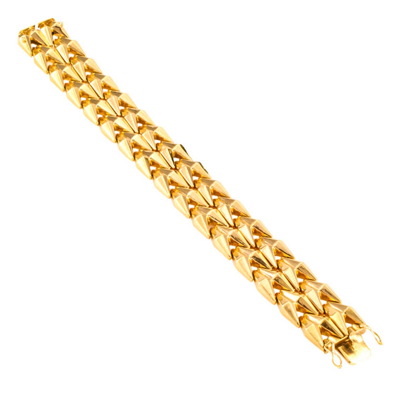 Spritzer And Furman 1950s Retro Gold Bracelet

A strap of sculptured 18 karat gold comprising flexible links designed as triple strands of conjoined twin conical shapes with flat angular sides that, given the slightest movement of the wrist, catch