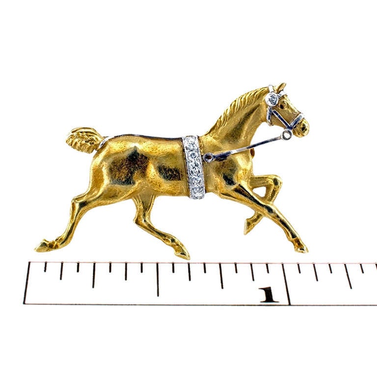 Art Deco Gold and Diamond Galloping Horse Pin - Circa 1920
This lovely  small scale design embellished with  accents detailing muscles in action. A white gold bridle with diamond accent, diamond girth, and  red enamel eye.  The diamonds totaling