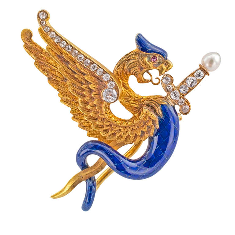 This graceful Art Nouveau griffin decorated with blue enamel is very unusual. Notice the fine detailing with scales painted on.  The wings, neck and face are meticulously hand engraved, inviting the eyes to see each individual feather's quill, even