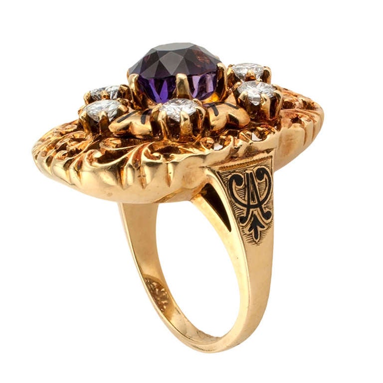 This unique oval-shaped designed dinner ring features a claw-set circular amethyst, framed by a radiating motif decorated with black enamel and six round diamonds totaling approximately 1.00 carat, approximately H color and VS clarity, on an