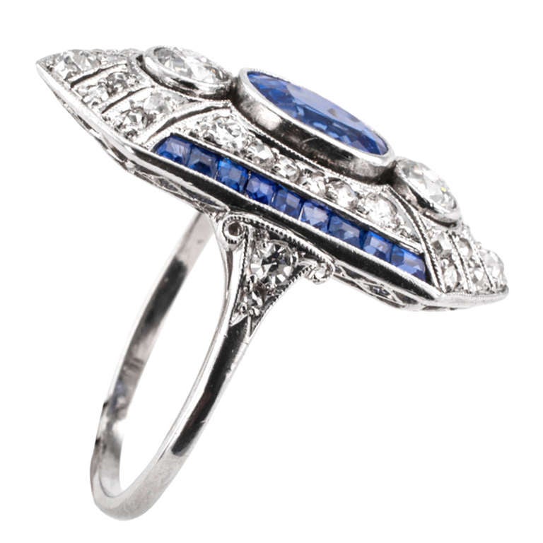This elongated design has a really beautiful color combination between the diamonds and the sapphires.  It is ultra deco!  The center sapphire weighing approximately 1.25 carats, the diamonds totaling approximately 0.90 carat.  Most unique in