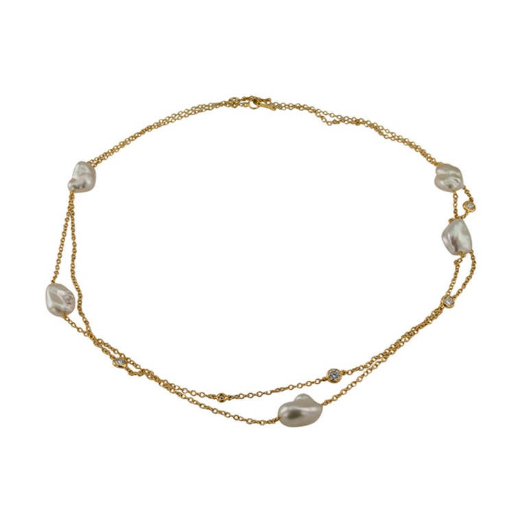 Simplicity and elegance are combined in this timeless design composed of five keshi pearls averaging 13 X 10 mm in size, alternating at random intervals with seven bezel-set round brilliant-cut diamonds totaling approximately 0.85 carat, connected