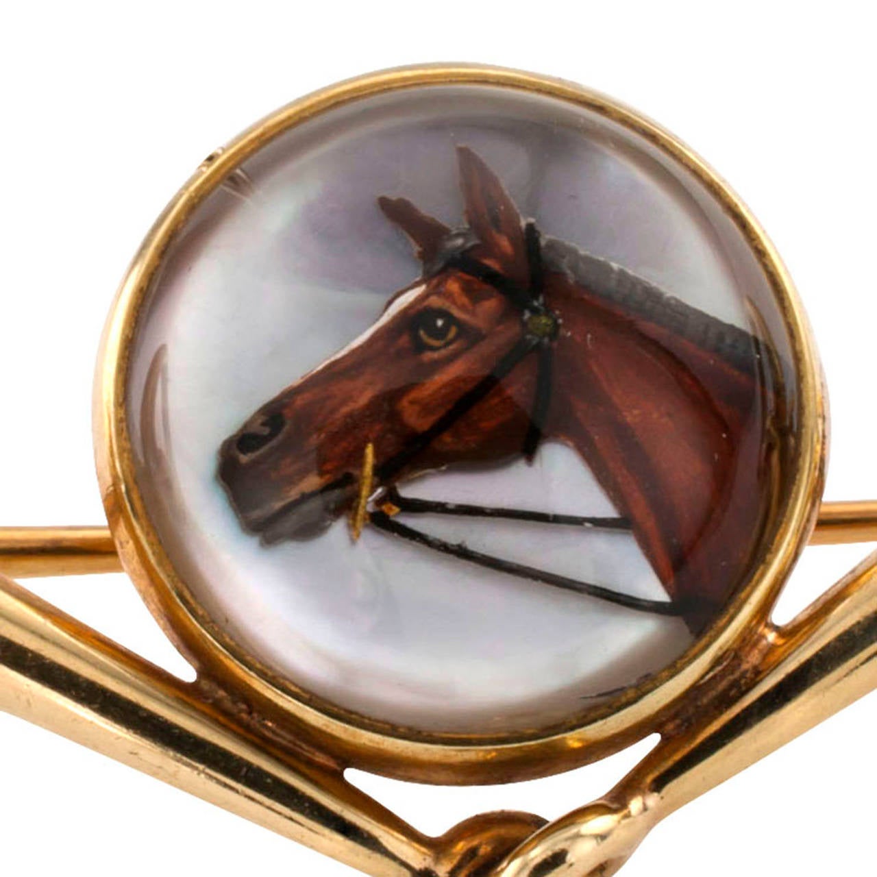 Early 20th Century Equestrian Essex Crystal Brooch

This lovely brooch centers upon a circular reverse carved rock crystal portrait depicting the head profile of an elite horse, supported by a set of horse bits, crafted in 14 karat gold, very well