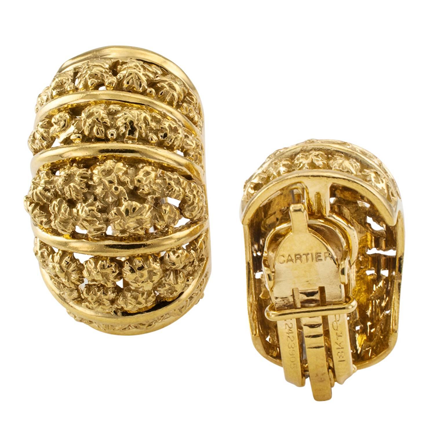 Cartier Estate Clip-On Gold Earrings 

Very classy and rich 18 karat yellow gold half hoop designs embellished with small flower like matte gold nuggets within a frame comprising arched bright polish gold bars.  Clip backs, signed Cartier,