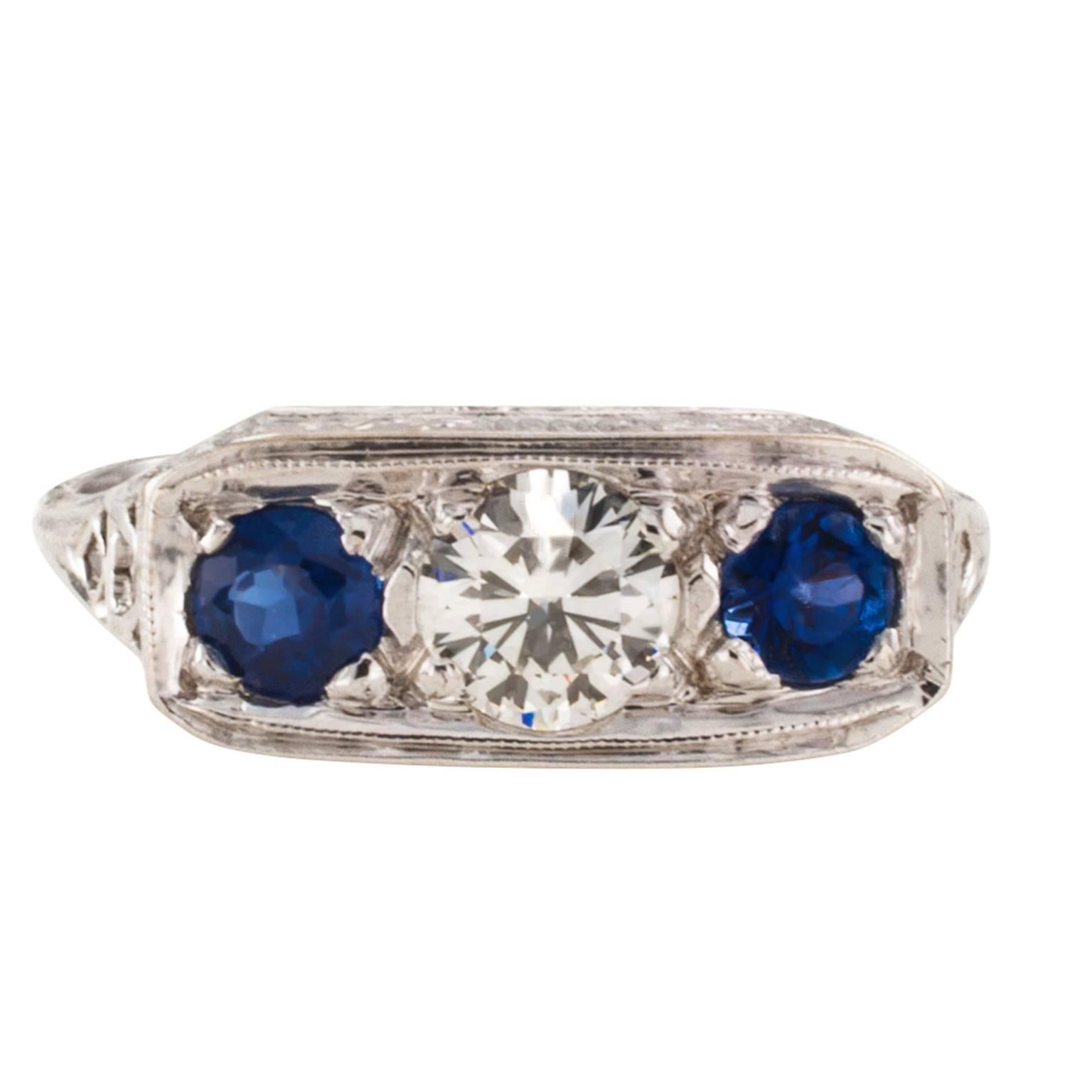 Art Deco Three-Stone Ring

Distinctive and traditional Art Deco three-stone ring centering upon a round diamond weighing approximately 0.45 carat, approximately K color and VS clarity, flanked by a pair of circular-cut sapphires totaling