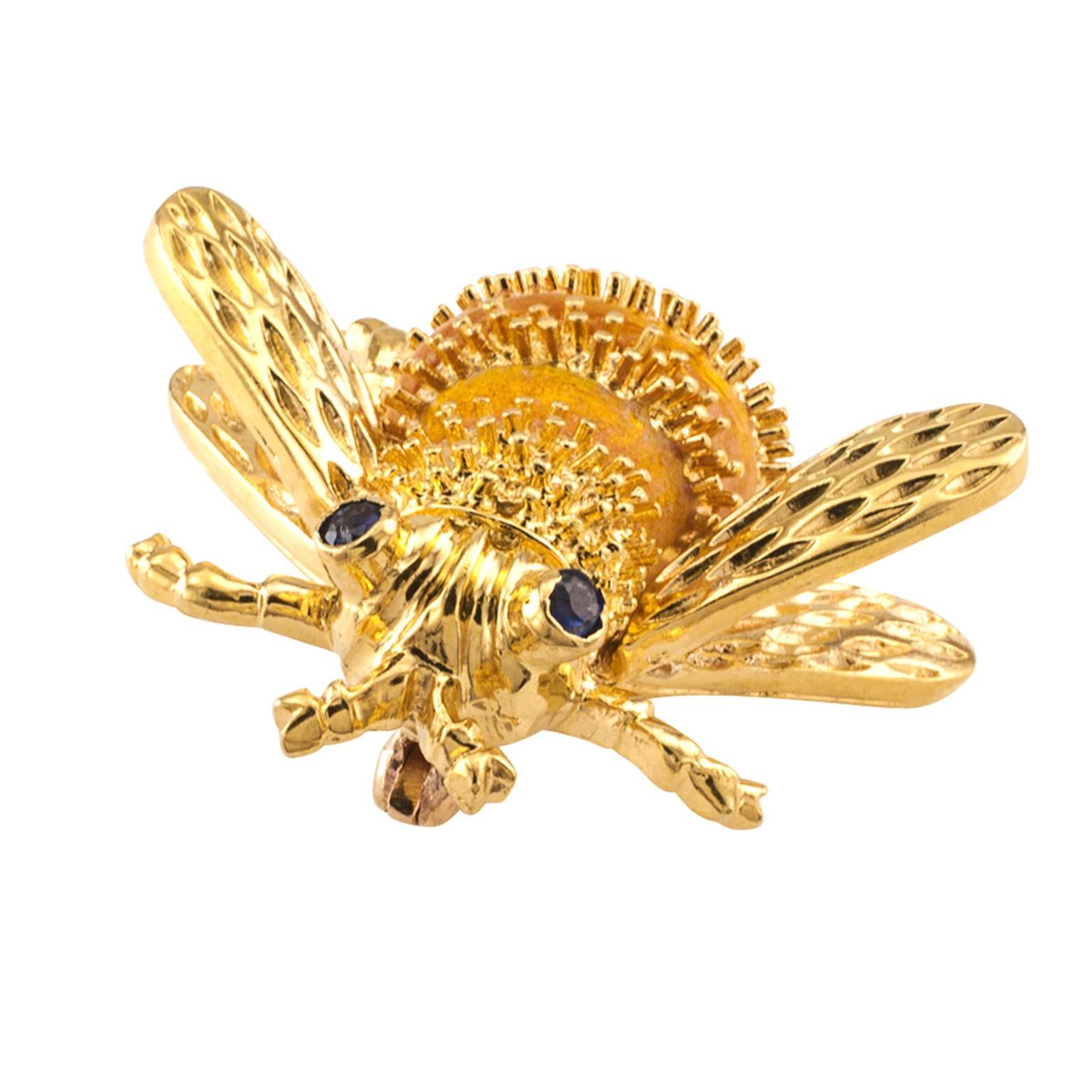 Sapphire Enamel and Gold Bee Brooch

Busy, pretty and dainty bumble bee with blue sapphire eyes, the abdomen decorated by alternating bands of textured gold and translucent amber-honey colored enamel.  Buz, Buz, Buz!  Crafted in 18 karat yellow