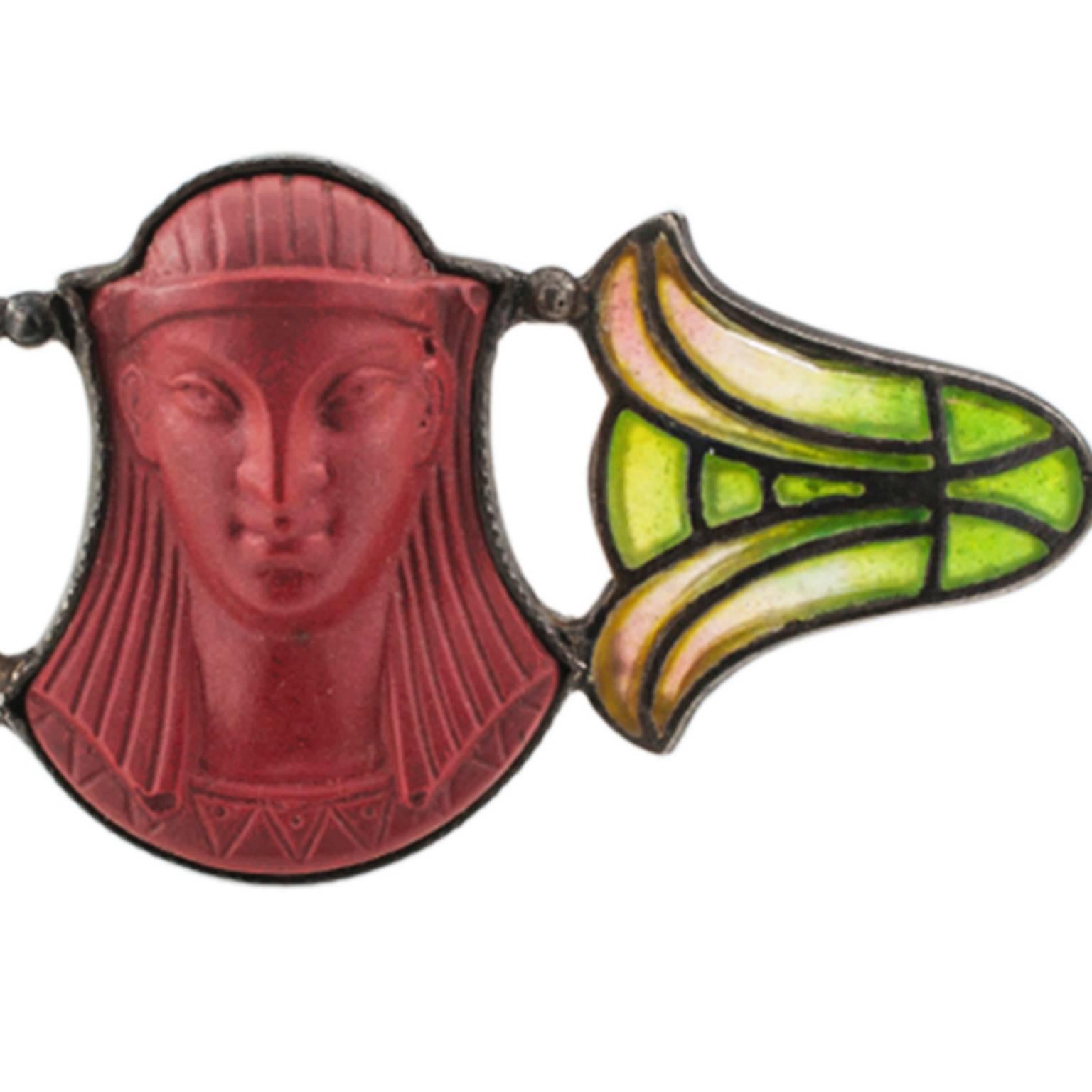Plique a Jour Egyptian Revival Antique Brooch

Wonderfully preserved, the carved pharaonic face framed in all its majesty by the mystical glowing light of a pair of tulip flowers... The alluring magic of antique treasures comes in all shapes, all