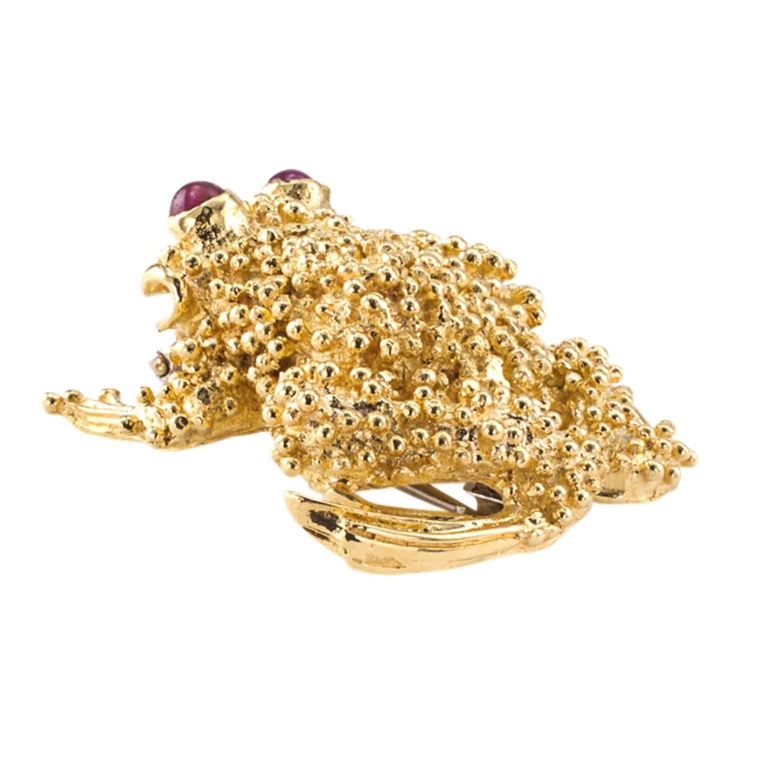 Toad Brooch in 18 Karat Yellow Gold and Cabachon Ruby Eyes

Cute, cute... That smile! Irresistible.  It might be a prince in disguise, after all.  An 18 karat gold toad with ruby eyes and that smile.  It will make you smile right back at it. 