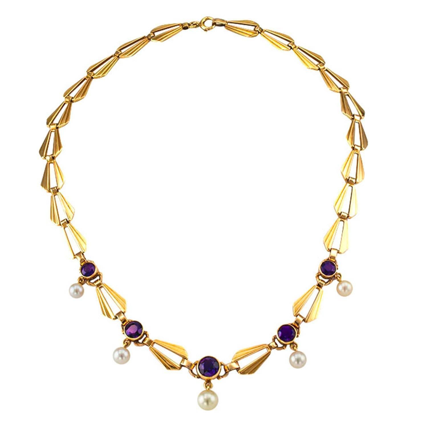 Retro Amethyst and Cultured Pearl Gold Necklace Circa 1950

Decorated on the front by five bezel-set round amethyst, each suspending a round cultured pearl ranging from 7 – 5.5 mm, connected by elongated, open and fluted links, mounted in 14-karat