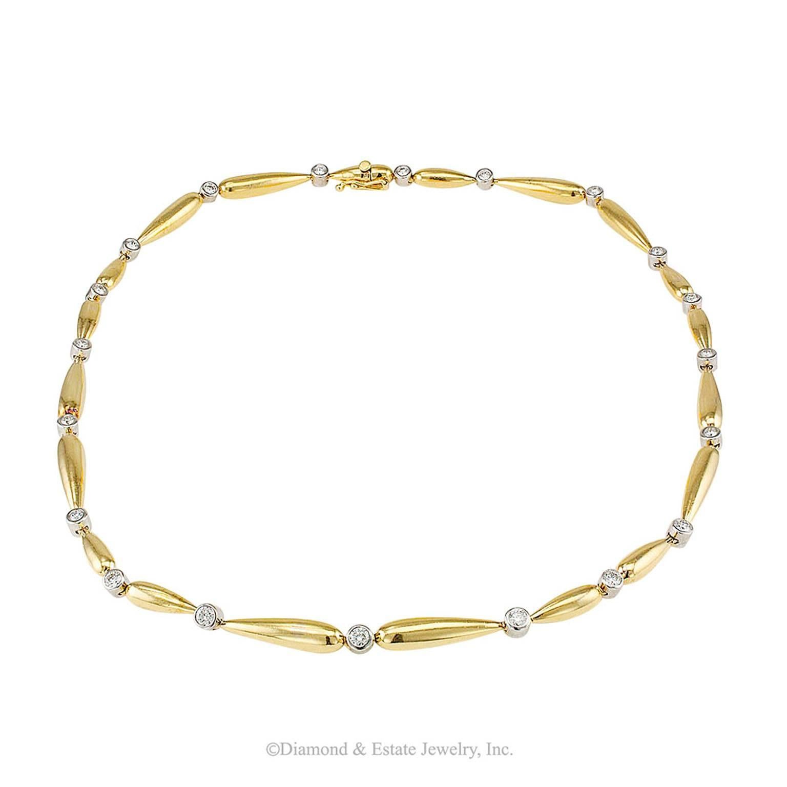 1980s Two Tone Gold Diamond Collar

Two-tone 18-karat gold and diamond articulated collar circa 1980.  The design is composed by a series of elongated, teardrop-shaped yellow gold sections connected by round diamonds bezel-set in white gold.  The