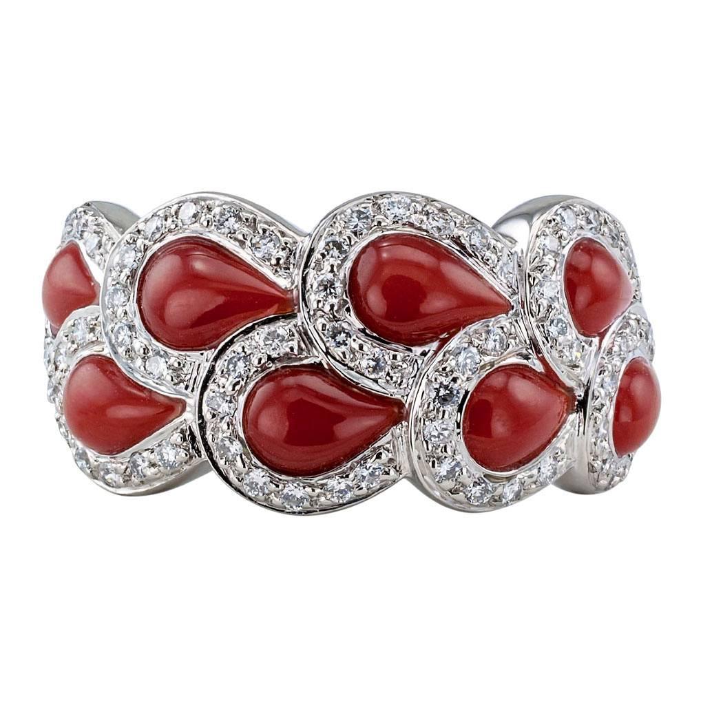 Red Coral Diamond Platinum Ring Band

Red coral and platinum wide ring band circa 1990. Designed as a ribbon of diamond-framed, teardrop-shaped red coral cabochons mounted in platinum, the diamonds totaling approximately 0.33 carat. Here then, is a