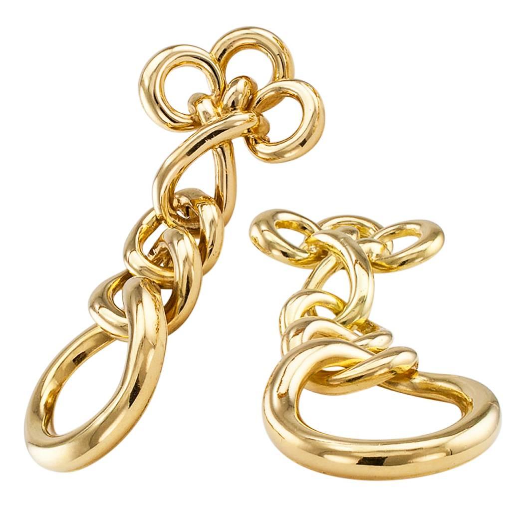 Italian 1970s 18 karat gold drop ear clips. Designed as an articulated row of graduating, tubular gold links surmounted by a trio of interlocked loops. This is a delicious pair of ( I feel pretty.) chic and playful earrings, long and luxurious, that