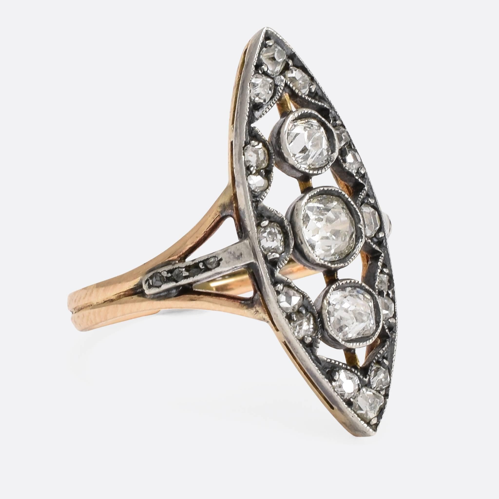 This superb antique Russian ring is set with .92ctw of old and rose cut diamonds, on a marquise shaped head. The stones are set in silver, with fine millegrain detail, and the trifurcated shoulders are accented with further diamonds. The reeded band