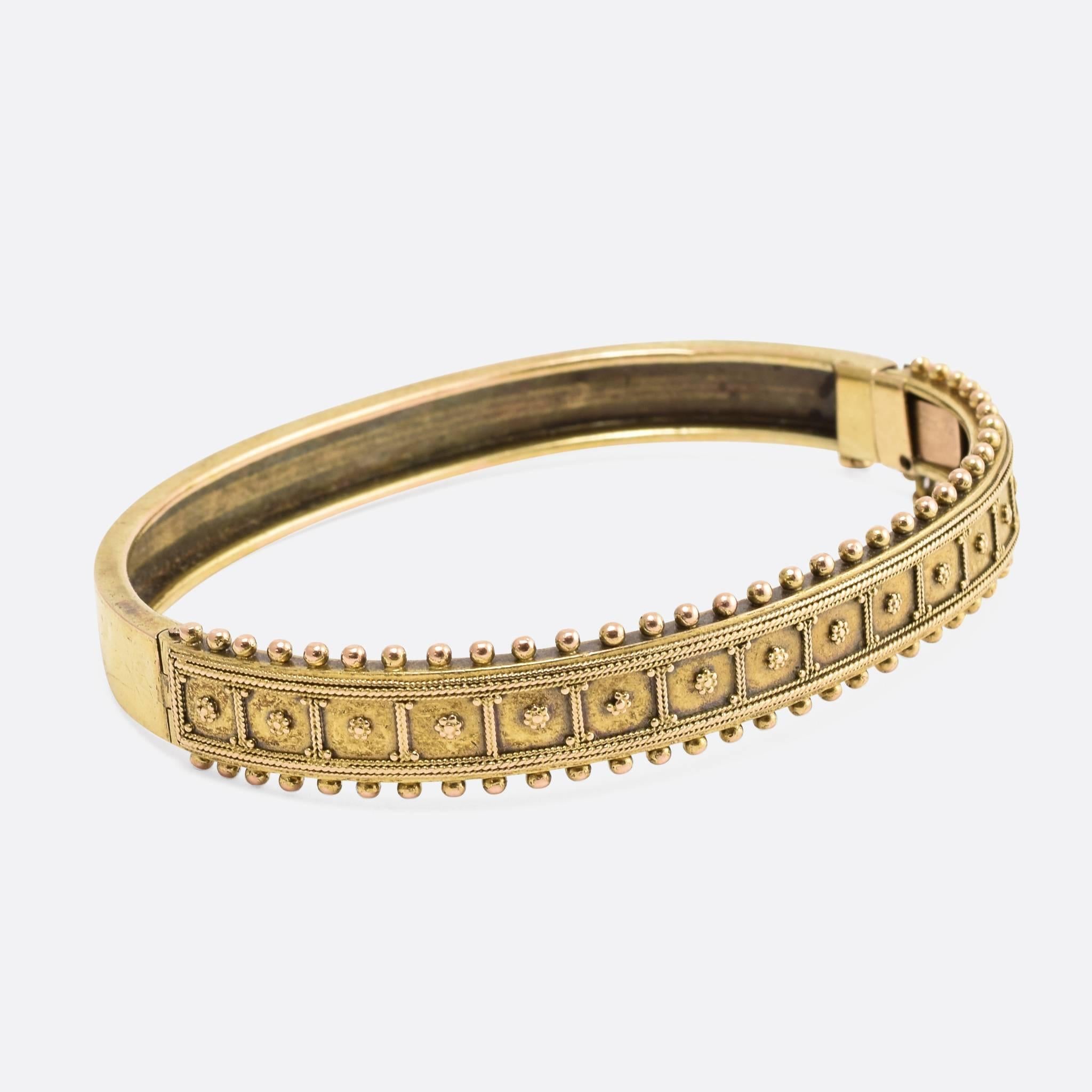This attractive antique bangle dates to the mid-Victorian era, and is modelled in the Etruscan Revival style - with pretty pommel and applied rope-work designs. It's crafted from 15ct gold, and has acquired a gorgeous antique patina.