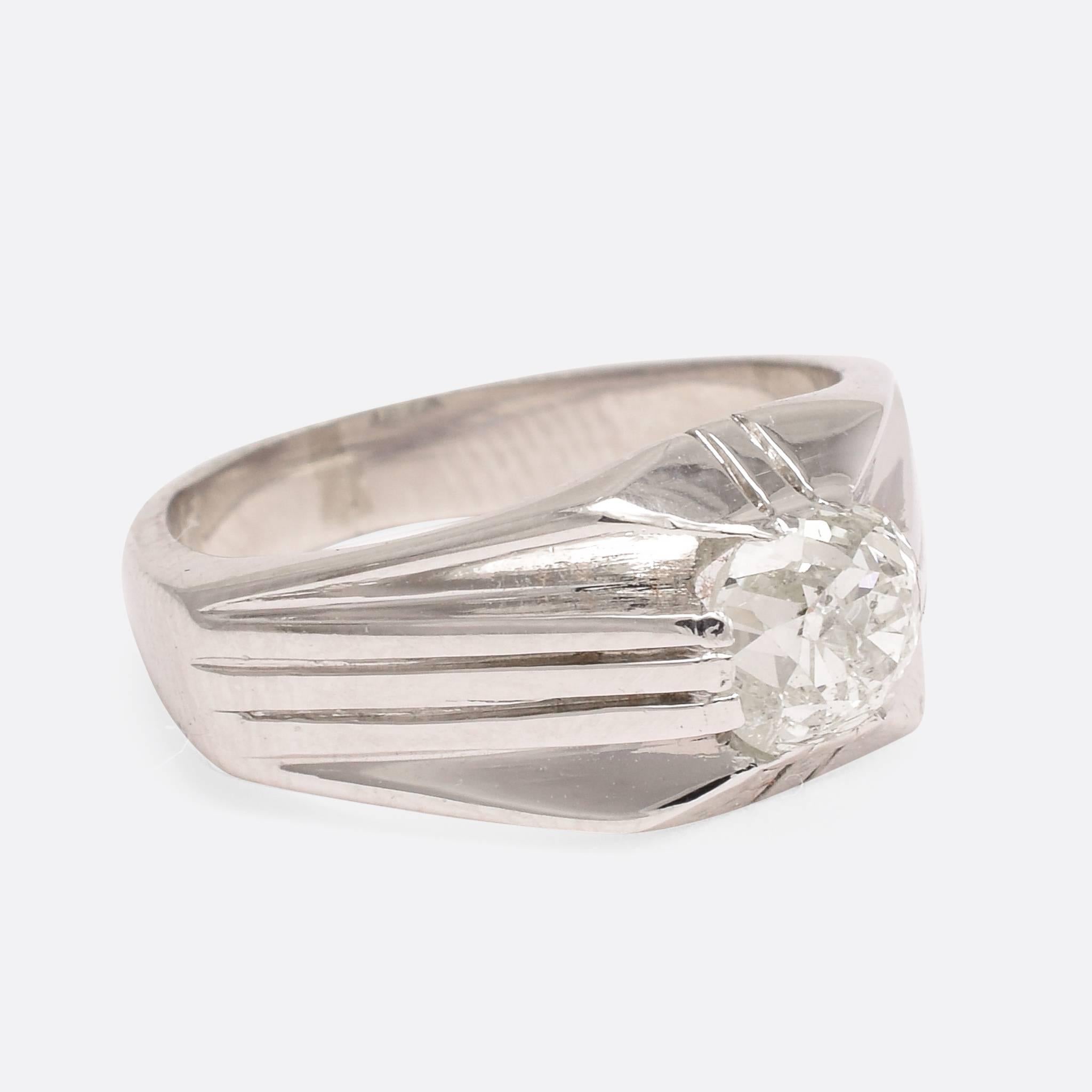 This exceptional 1930s Art Deco ring is modelled in platinum, and set with a chunky 1.2ct cushion cut diamond. The unusual flat shoulders are grooved, and draw the eye towards the main event: that wonderful antique diamond. The stone was likely cut