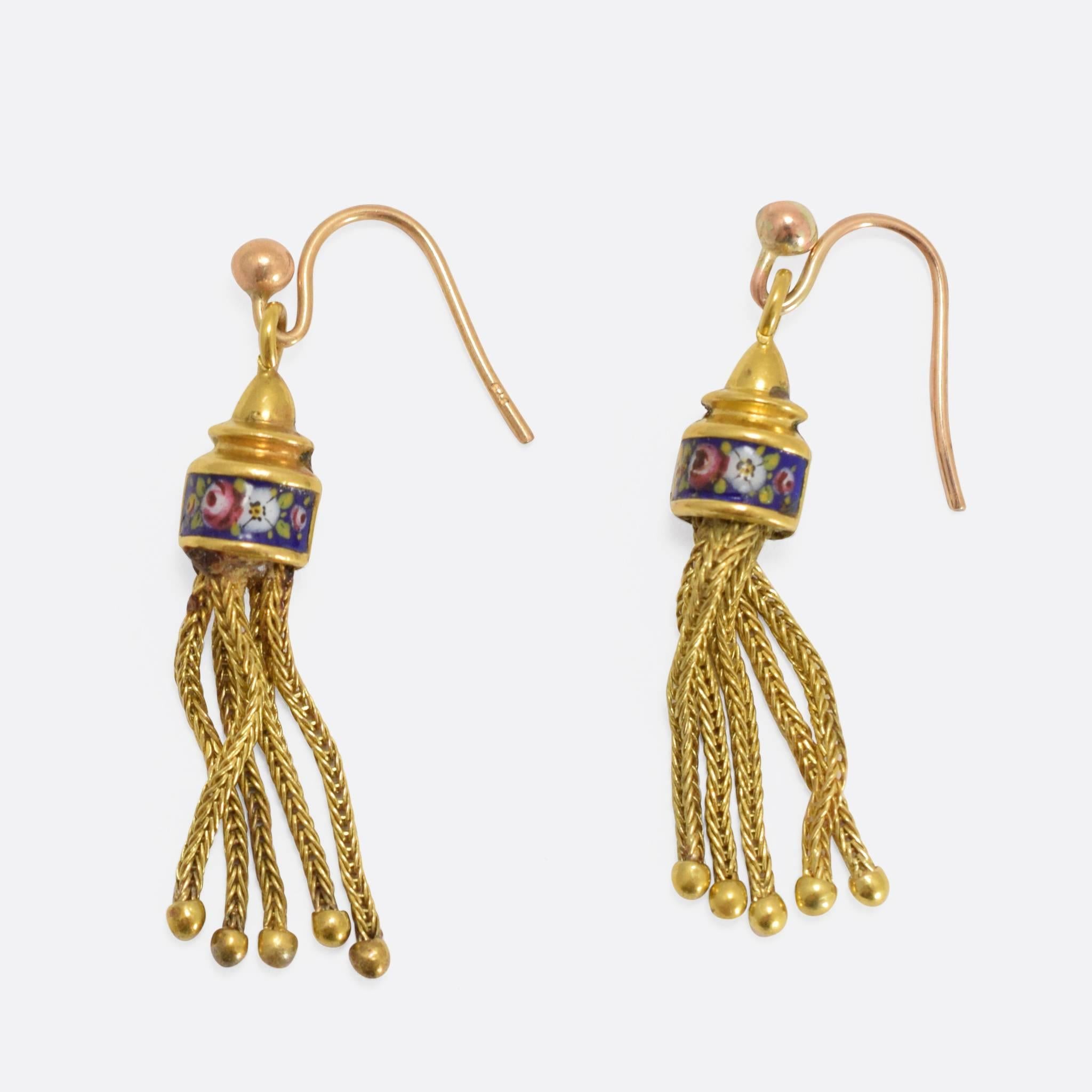 This beautiful pair of tassel earrings is modelled in 15ct yellow gold. The heads are adorned with a band of enamel, featuring cute floral designs. The tops are likely later additions.