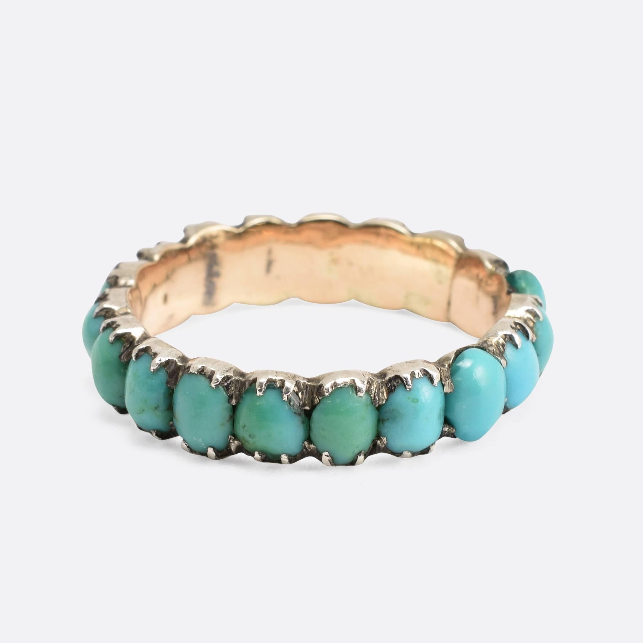 This attractive antique eternity ring is fully set with oval turquoise cabochons. Modelled in 15ct gold, the stones are set in pretty silver claw settings. Ring Size: US: 4, or UK: H 1/2.