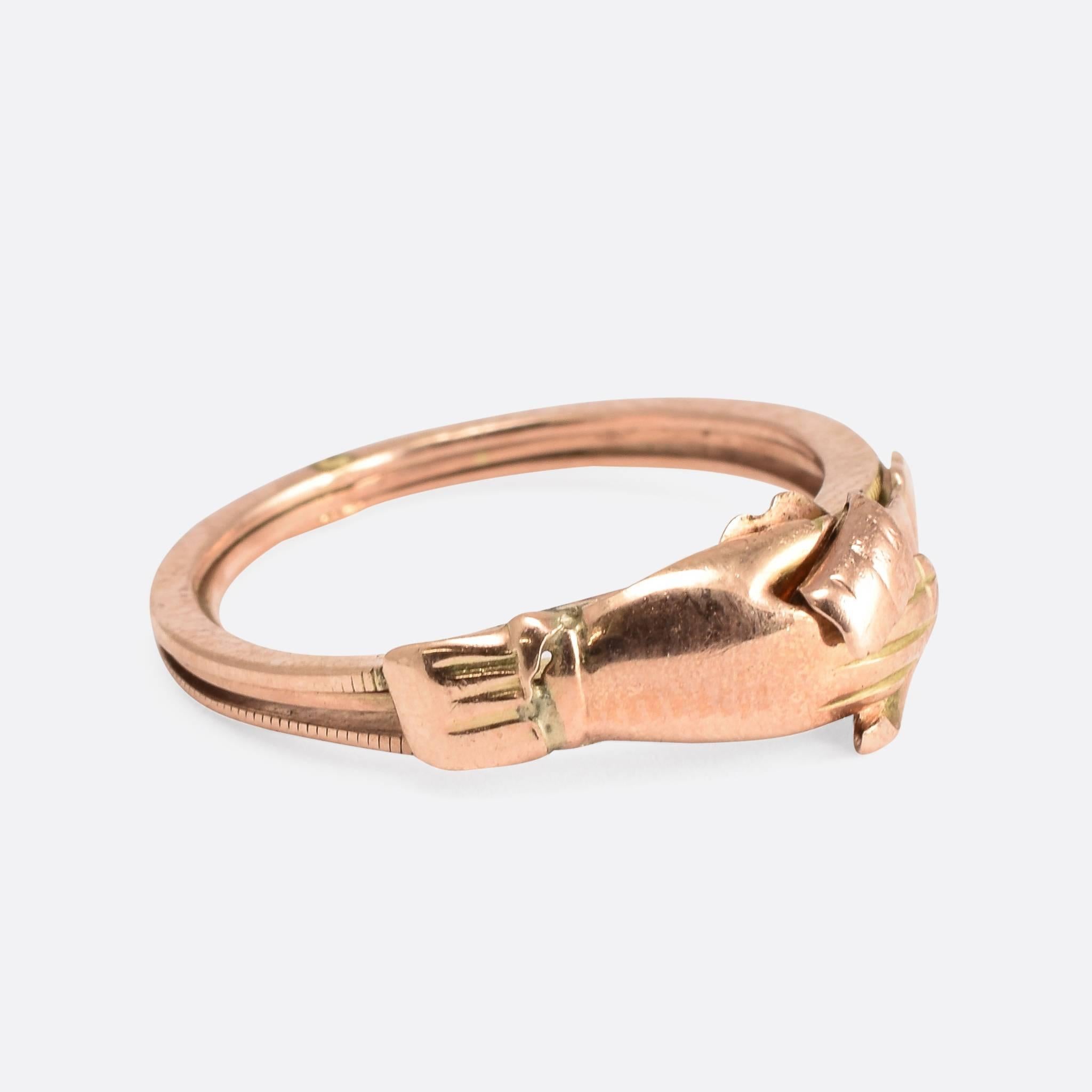 This wonderful antique gimmel fede ring is modelled in 9ct rose gold. Comprised of three separate rings - joined at the back - the hands unclasp to reveal a double heart motif. Ring Size: US: 5.25, or UK: K