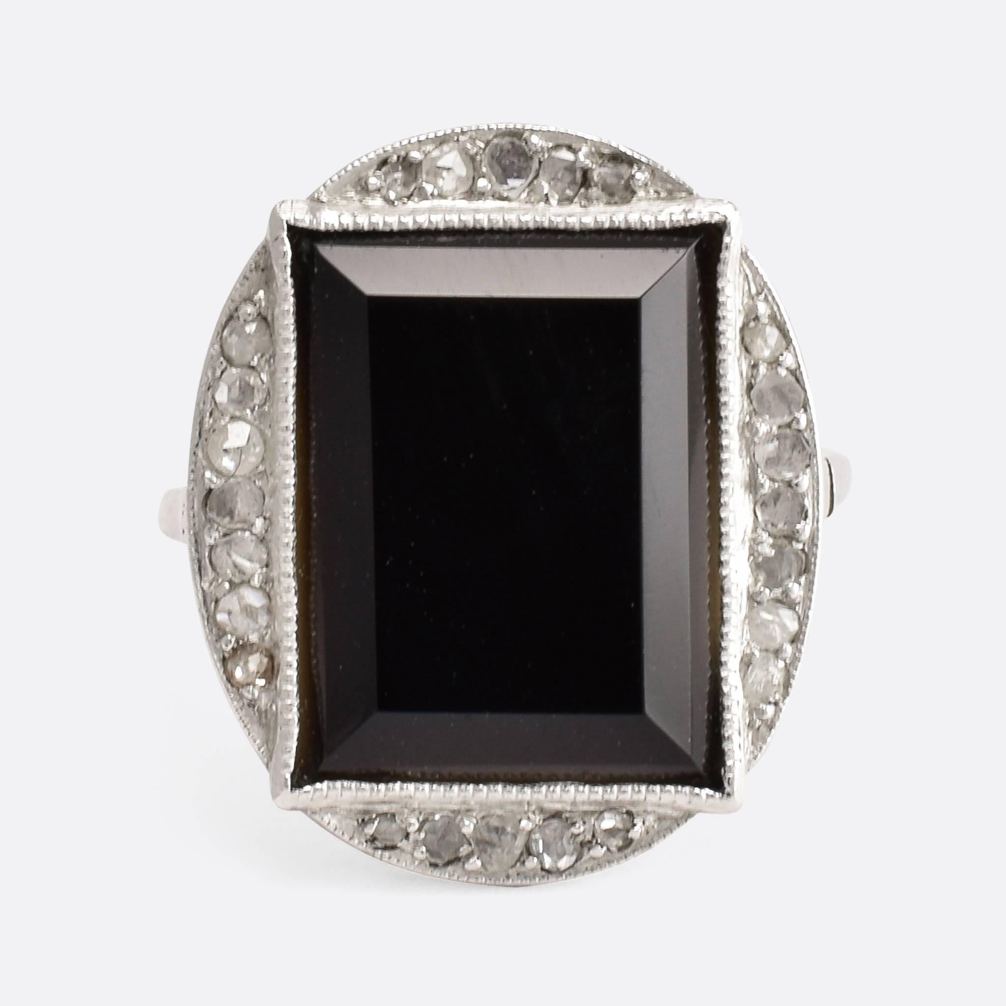 This fabulous Art Deco ring has an oversized head, set with a large slab of black onyx and rose cut diamonds. The platinum settings feature fine millegrain detail with a pretty galleried underside. A spectacular, and highly unusual statement ring,