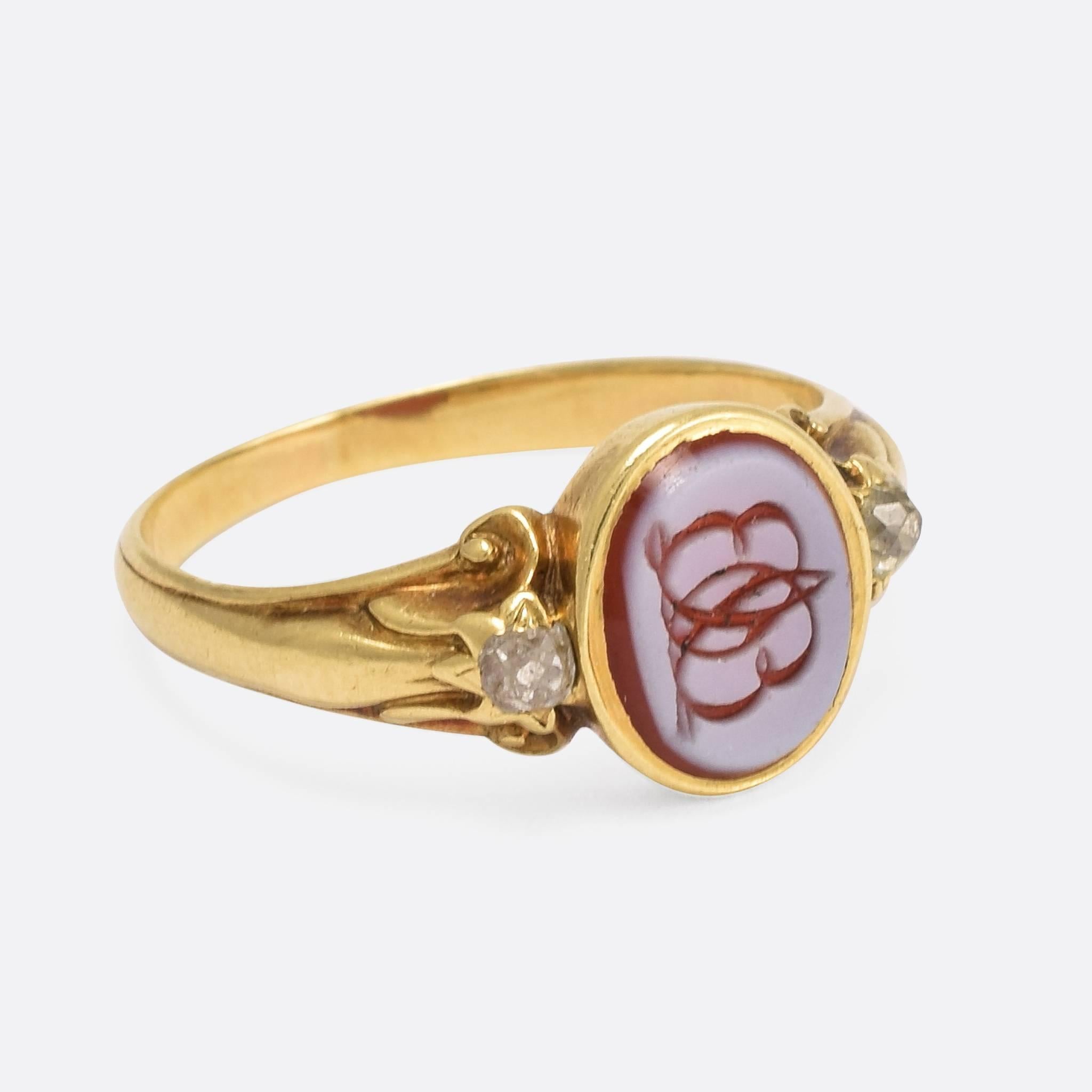 This attractive Victorian Signet Ring is set with two old cut diamonds in the shoulders, and features a sardonyx panel with hand-carved mirrored monogram of the letters EL. Modelled in 15ct gold, the ring bears a date engraved on the inner band: