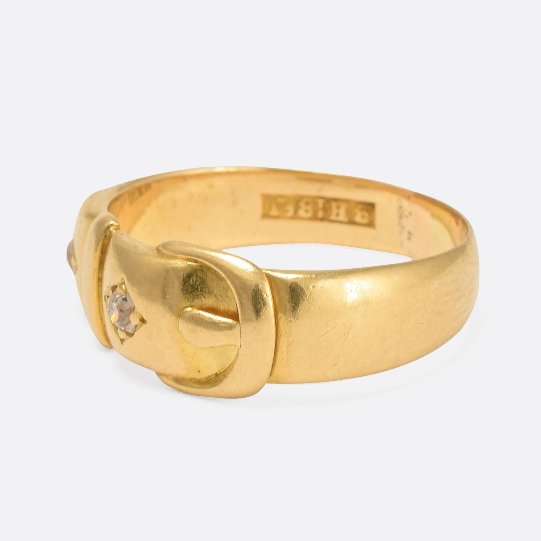 This lovely antique buckle ring is modelled in 18ct yellow gold, and set with two old mine cut diamonds. A timeless ring that displays beautiful craftsmanship. Ring Size: US: 6.5, or UK: M 1/2. Width of band: 3.7mm.